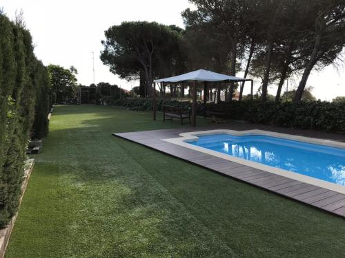 a swimming pool in a yard with a table and a umbrella at Casa con piscina Sant Pol de Mar in San Pol de Mar