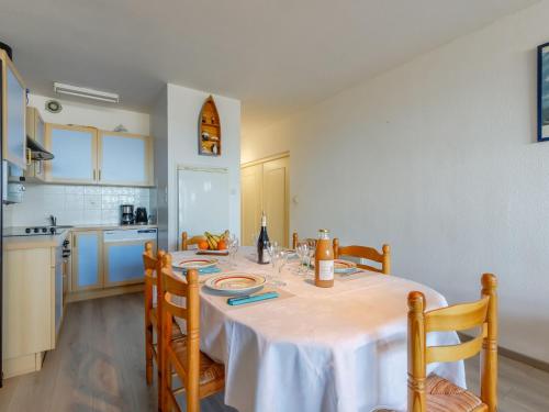 une cuisine avec une table et un chiffon de table blanc dans l'établissement Apartment Vue Mer -Apt 2 pièces-alcove-5 pers- by Interhome, à Les Bains