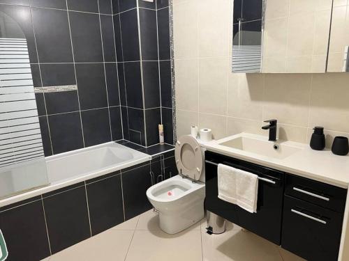 La salle de bains est pourvue de toilettes, d'un lavabo et d'une baignoire. dans l'établissement Super appart 50m² avec jardin V2, à Villeneuve d'Ascq