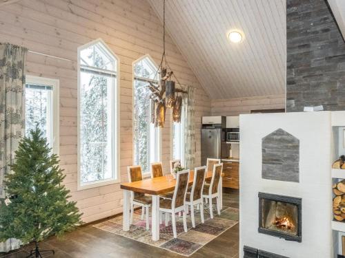 een eetkamer met een tafel en een open haard bij Holiday Home Levin taiga 18 a by Interhome in Sirkka