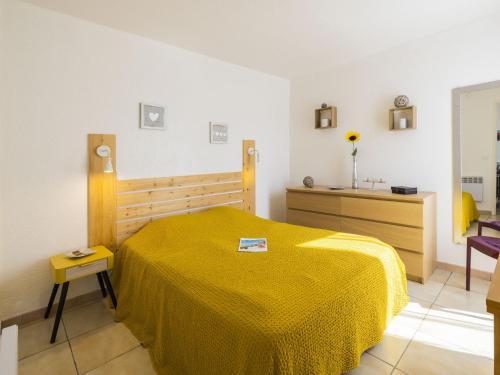 - une chambre avec un lit et une couverture jaune dans l'établissement Apartment Les Mirandas II by Interhome, à Saint-Cyprien