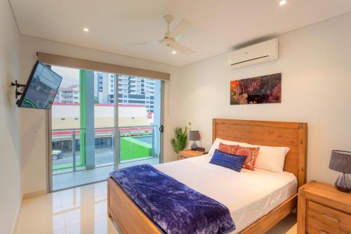 a bedroom with a bed and a large window at Crocs on Cavenagh in Darwin