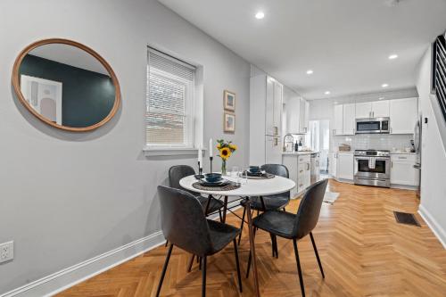 a dining room with a table and chairs and a mirror at Modern & Comfy ~ 5* Location~GameRoom~Backyard in Philadelphia
