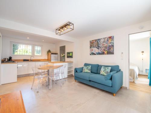 un salon avec un canapé bleu et une cuisine dans l'établissement Apartment Le Jasmin by Interhome, à Cavalaire-sur-Mer