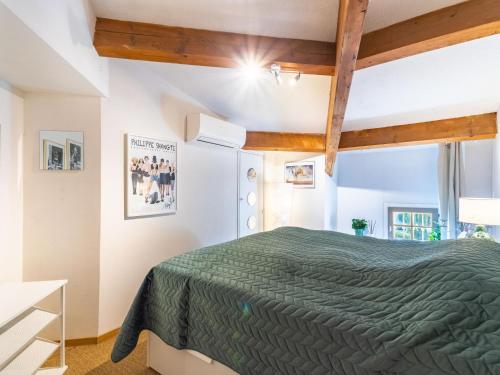 - une chambre avec un lit vert et des poutres en bois dans l'établissement Apartment Le Clos Sainte Anne-1 by Interhome, à Saint-Tropez