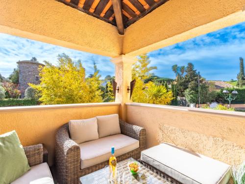 - une terrasse couverte avec des chaises en osier et une table dans l'établissement Apartment Le Clos Sainte Anne-1 by Interhome, à Saint-Tropez