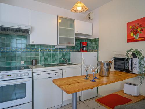 cocina con electrodomésticos blancos y mesa de madera en Apartment Le Galion by Interhome, en La Trinité-sur-Mer