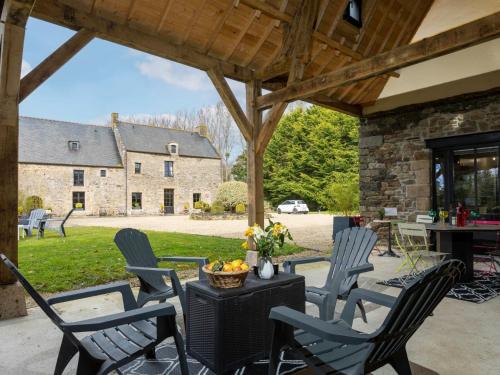 un patio avec des chaises et une table et un bâtiment dans l'établissement Holiday Home Les Grands Près by Interhome, à Cancale