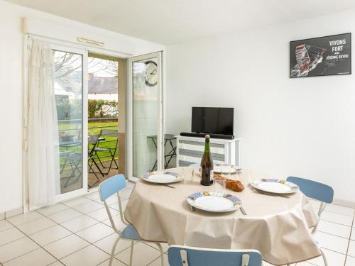a dining room with a table and chairs and a television at Apartment Les Caps Horniers by Interhome in Pleurtuit
