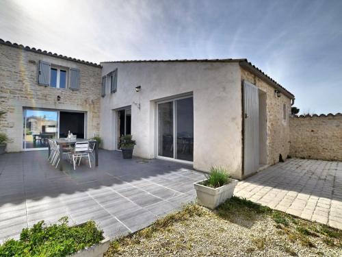 a patio with a table and a building at Holiday Home Les Oyats by Interhome in Dolus d'Oléron