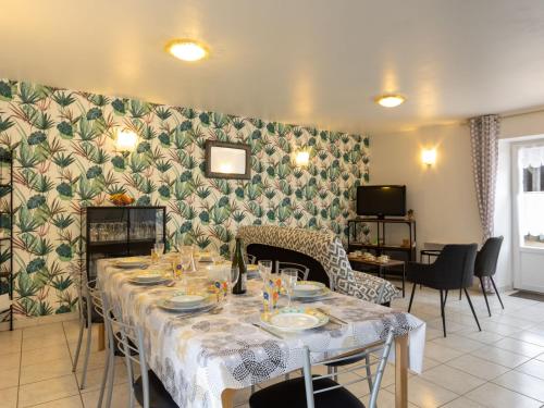 una sala da pranzo con tavolo, sedie e parete di Holiday Home Coquelicot by Interhome a Saint-Méloir-des-Ondes