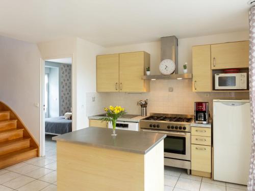 uma cozinha com armários de madeira e um forno com placa de fogão em Holiday Home Coquelicot by Interhome em Saint-Méloir-des-Ondes
