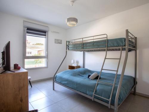 - une chambre avec des lits superposés et une télévision dans l'établissement Apartment L'Orée du parc by Interhome, à Villeneuve-Loubet