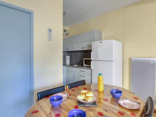une cuisine avec une table en bois et un réfrigérateur blanc dans l'établissement Studio L'Astrolabe by Interhome, à Saint-Cyr-sur-Mer