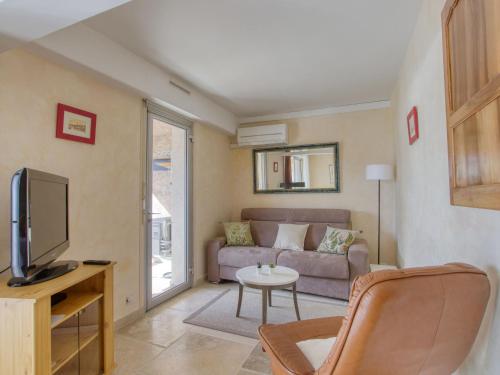 un salon avec un canapé et une télévision dans l'établissement Apartment Le port des lecques by Interhome, à Saint-Cyr-sur-Mer