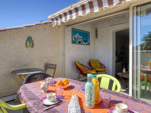 une table avec un bol de fruits sur une terrasse dans l'établissement Apartment Jardins de la mer-11 by Interhome, à Saint-Cyr-sur-Mer