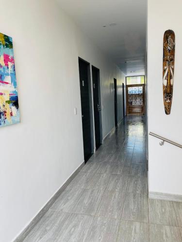 a hallway with black doors and a painting on the wall at Murano Hotel in Coveñas
