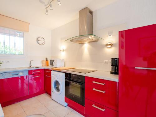 - une cuisine avec des placards rouges et un lave-linge dans l'établissement Apartment La Bastide-2 by Interhome, à Sainte-Maxime