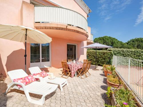 un patio avec une table, des chaises et un parasol dans l'établissement Apartment La Bastide-2 by Interhome, à Sainte-Maxime