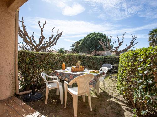 une table et des chaises assises sur une terrasse dans l'établissement Apartment Le Hameau du Rivage-15 by Interhome, à Saint-Cyprien