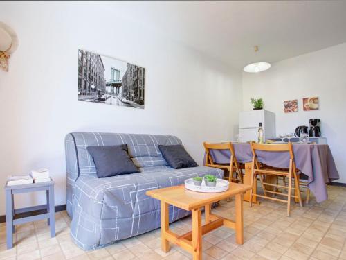 un salon avec un canapé bleu et une table dans l'établissement Apartment Le Hameau du Rivage-15 by Interhome, à Saint-Cyprien