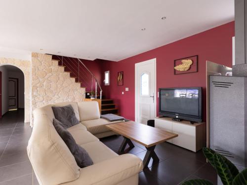 un salon avec un canapé blanc et une télévision dans l'établissement Holiday Home Lesgau by Interhome, à Saint-Martin-de-Seignanx
