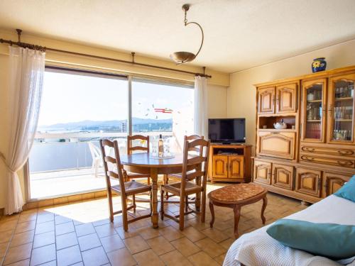 ル・ラヴァンドゥーにあるApartment Les 3 Iles by Interhomeのテーブルと椅子と大きな窓のあるダイニングルーム