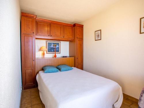 - une chambre avec un lit blanc et des placards en bois dans l'établissement Apartment Les 3 Iles by Interhome, au Lavandou