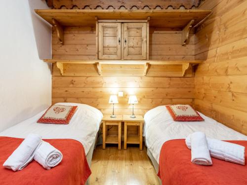 deux lits jumeaux dans une chambre aux murs en bois dans l'établissement Apartment Ecrin des Neiges - Val Claret-2 by Interhome, à Tignes
