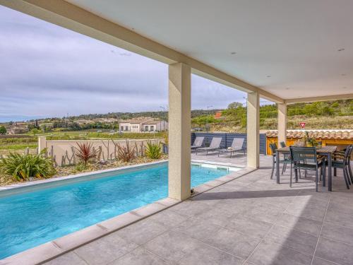 un patio avec une table et des chaises et une piscine dans l'établissement Holiday Home Villa Hestia by Interhome, à Goudargues