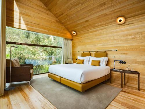 a bedroom with a large bed and a large window at Lavandeira Douro Nature & Wellness in Ancede
