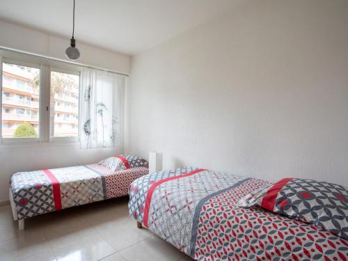 1 Schlafzimmer mit 2 Betten und einem Fenster in der Unterkunft Apartment Epsom by Interhome in Cagnes-sur-Mer