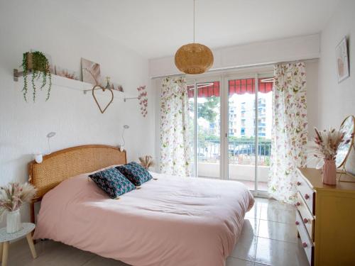 ein Schlafzimmer mit einem Bett und einem großen Fenster in der Unterkunft Apartment Epsom by Interhome in Cagnes-sur-Mer
