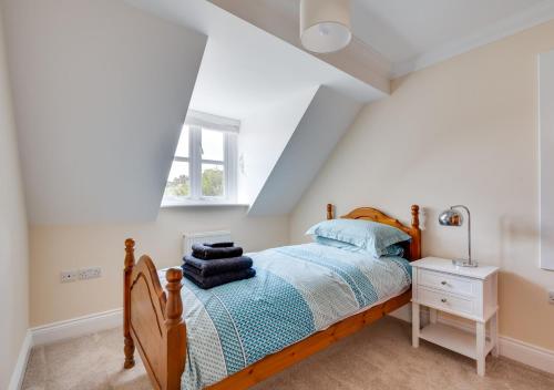 a bedroom with a wooden bed and a window at Sailors Rest in Wangford