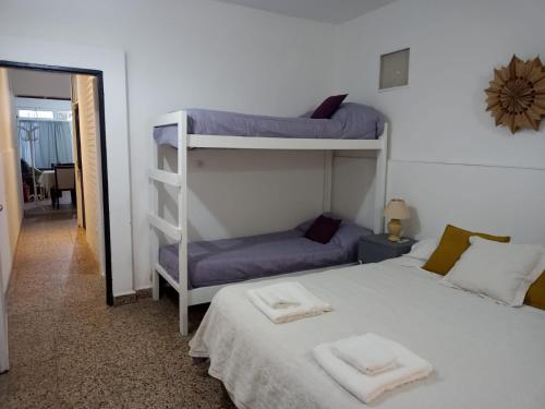 a bedroom with two bunk beds with towels on a bed at Cacique Catriel "EN PLANTA BAJA" in Catriel