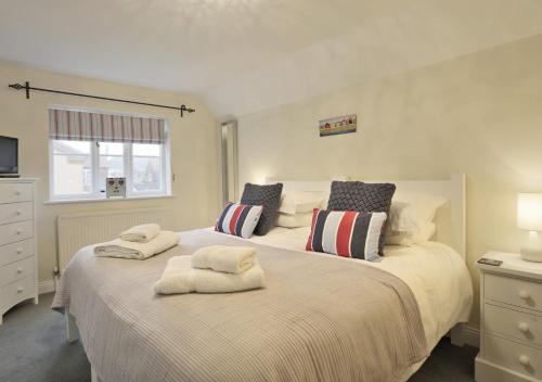 2 camas con toallas encima de ellas en un dormitorio en Sandcastle Cottage, en Southwold