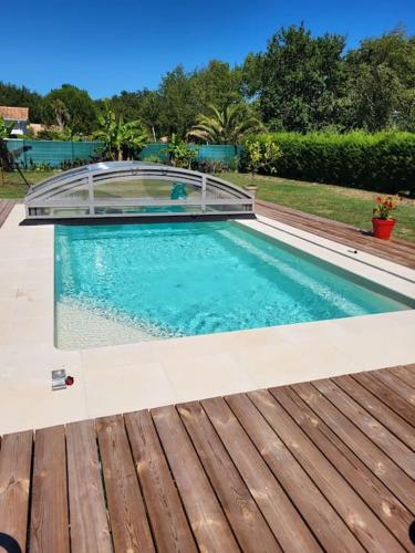 une grande piscine avec une terrasse en bois dans l'établissement Agréable maison familiale, à Carcans