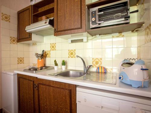 une cuisine avec un évier et un micro-ondes dans l'établissement Studio Montfleuri by Interhome, à Villeneuve-Loubet