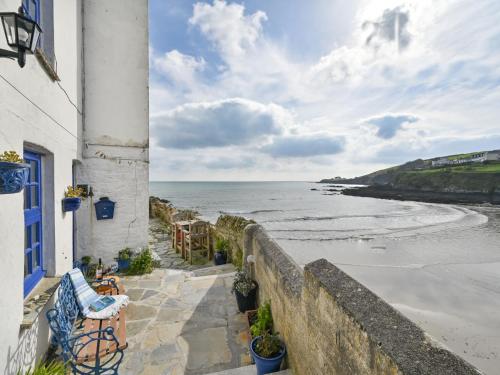 a house with a blue window and a view of the ocean at Holiday Home Dolphin Cottage by Interhome in Mevagissey