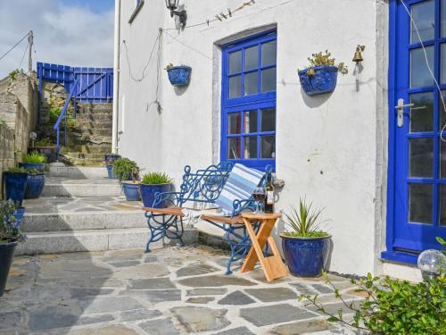a patio with blue doors and potted plants at Holiday Home Dolphin Cottage by Interhome in Mevagissey