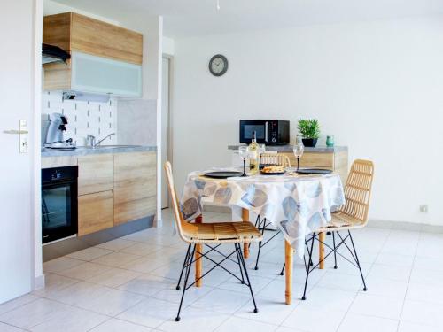 une cuisine avec une table et des chaises dans une pièce dans l'établissement Apartment Les Mas de La Mer-18 by Interhome, à Saint-Cyprien