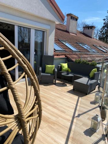 a patio with a wicker chair on a deck at Apartament MoLoo II in Ostróda