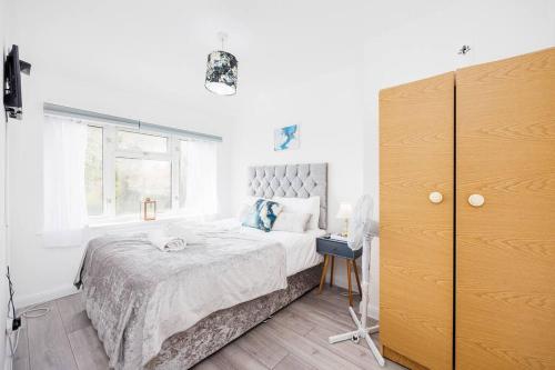Un dormitorio blanco con una cama grande y una ventana en Stunning 2 Bed House with Parking in Dagenham en Goodmayes