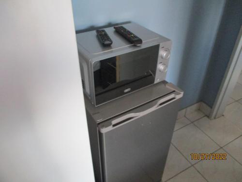a microwave oven sitting on top of a refrigerator at PS GOOD TIME GUEST HOUSE in Klerksdorp