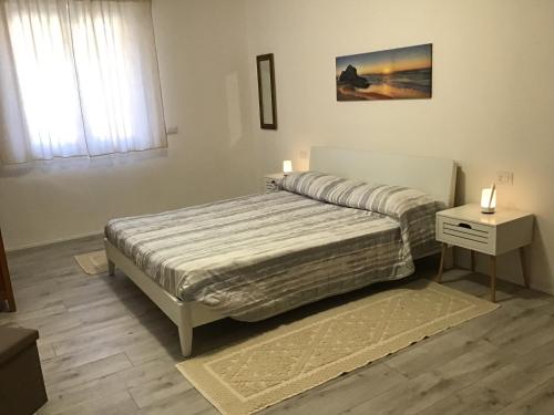 een slaapkamer met een bed en een tafel met twee kaarsen bij Il Parco IUN R1207 - Ingresso indipendente con quattro posti letto in Santa Giusta