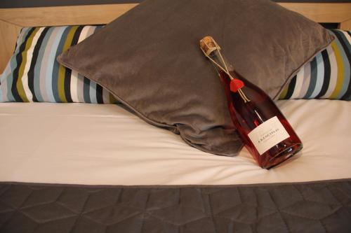 een fles wijn bovenop een bed bij Villa Louis Victor in Dizy