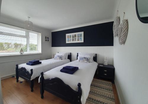 2 Einzelbetten in einem Schlafzimmer mit Fenster in der Unterkunft Sky View in Reydon