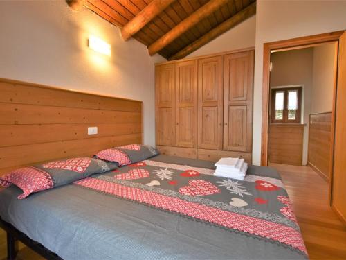 a bedroom with a bed with a wooden head board at Chalet Baita Lake View in Poira di Dentro