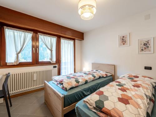 1 dormitorio con 2 camas y ventana en Apartment Condominio Giulia by Interhome, en Alba di Canazei