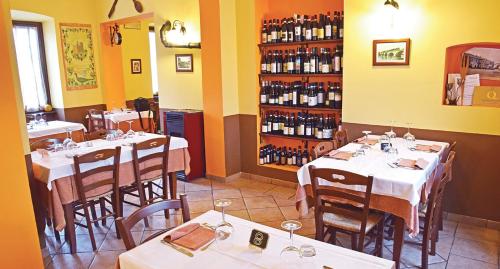 - une salle à manger avec des tables et des bouteilles de vin dans l'établissement POST A POST, à Alba